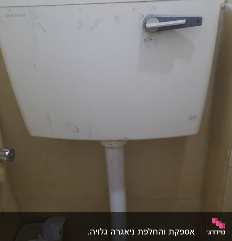 ניאגרה לבנה עם ידית מתכת בחדר אמבטיה